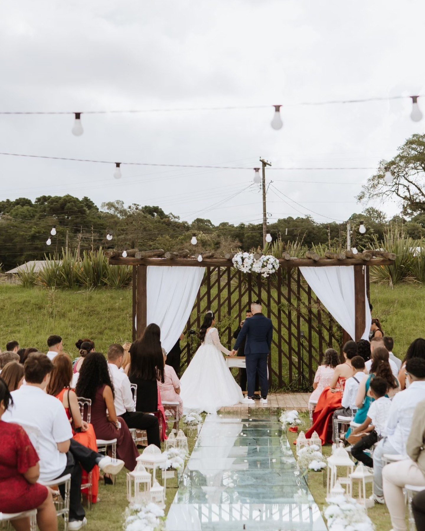 Cerimônia de casamento ao ar livre na Palazzo Umbará, com noivos sob pergolado e convidados